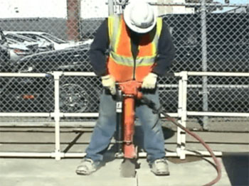 Figure 2: Worker using jackhammer with Lift Assist. (Note: Lift Assist is the black cylinder