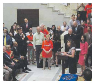 Marcy Goldstein-Gelb addresses the crowd gathered at the signing of the bill that increases the minimum wage in Massachusetts.