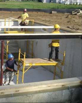 Figure 18 - Workers installing a steel beam from a mobile scaffold.
