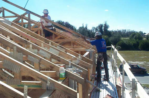 Figure 2 - Workers using an exterior bracket scaffold to install roof trusses.