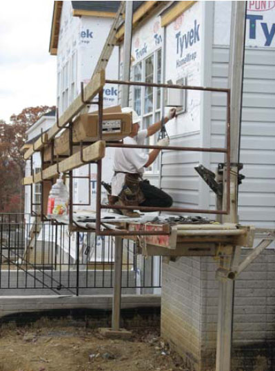 Figure 32 - A worker performing siding activities from a pump jack scaffold.