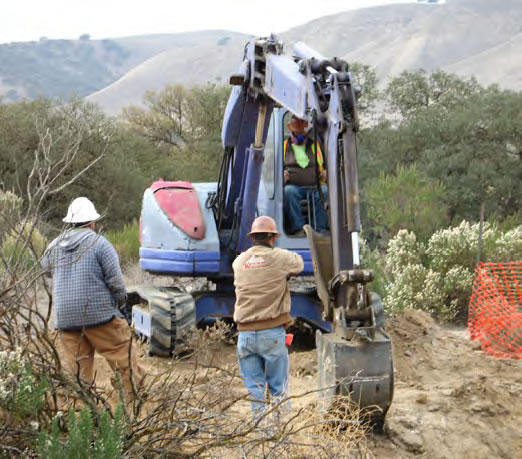 Photo of men standing next to construction equipment