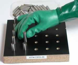 photo of a dexterit test where a gloved hand has to pick up metal plugs