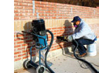 image of construction worker tuckpointing a brick wall