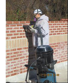 image of construction worker tuckpointing a brick wall