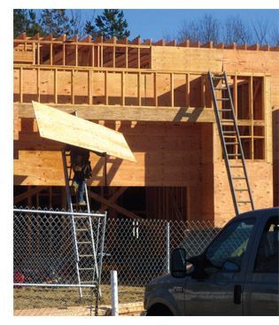 image of worker on ladder with plywood