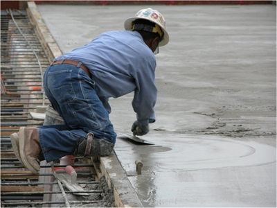 Man in an awkward position, kneeling and smoothing concrete. Photo courtesy CPWR’s electronic Library of Construction Safety and Health (eLCOSH).