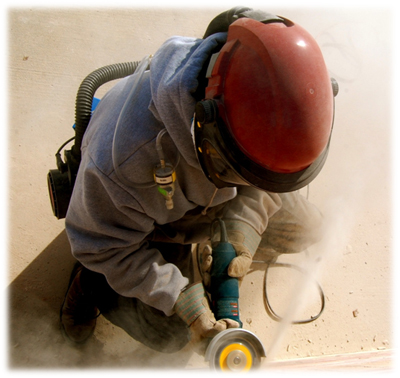 Photo of a worker using a saw while wearing protective clothing for the dust