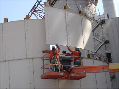Men on a lift putting a panel into place. Photo courtesy of International Brotherhood of Boilermakers. 
