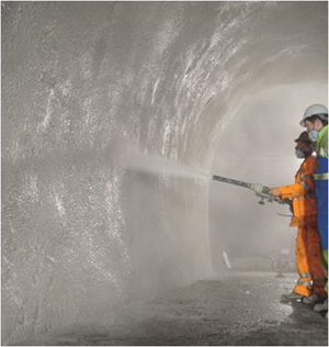 shotcrete being applied by workment covered with PPE