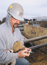 A contractor reads a penetrometer to determine the best protective system to use in an excavation to prevent a cave-in
